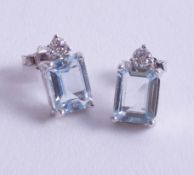 A pair of 18ct white gold diamond and aquamarine (emerald cut) earrings.