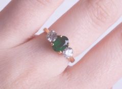 A fine 18ct emerald and diamond three stone ring, size L.