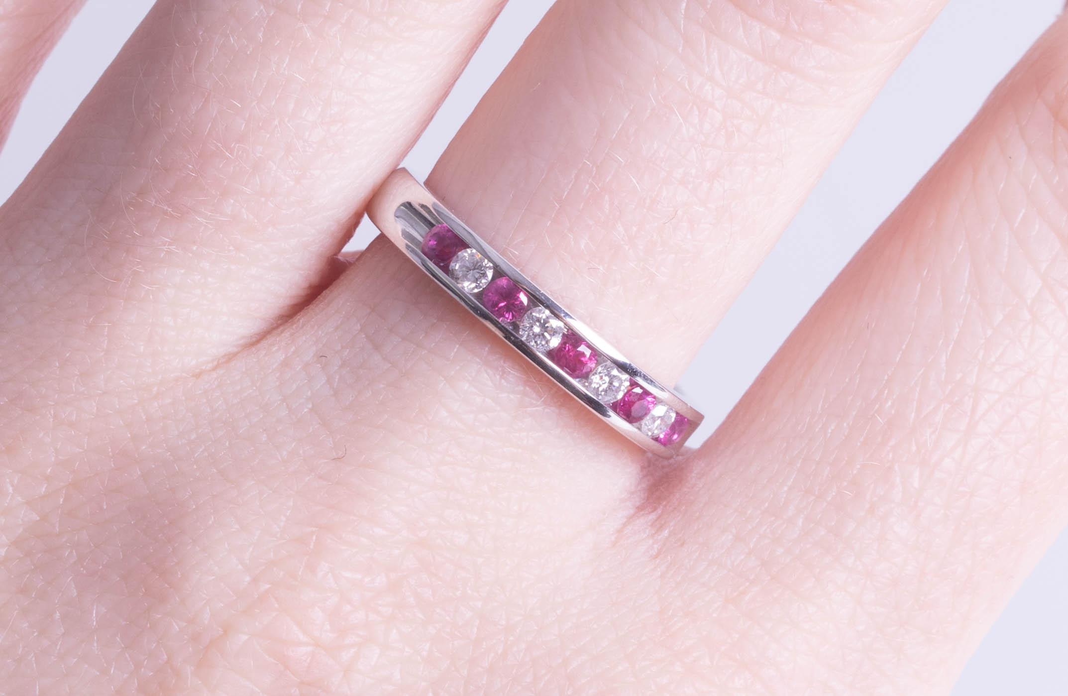 An 18ct white gold ruby and diamond set half band eternity ring, size O. - Image 2 of 2
