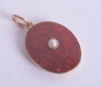 A gold, red enamelled and pearl set locket.