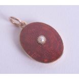 A gold, red enamelled and pearl set locket.