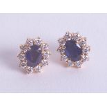 A pair of sapphire and diamond cluster earrings set in yellow gold.