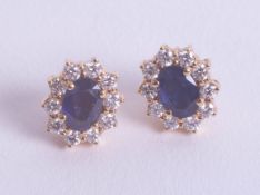 A pair of sapphire and diamond cluster earrings set in yellow gold.