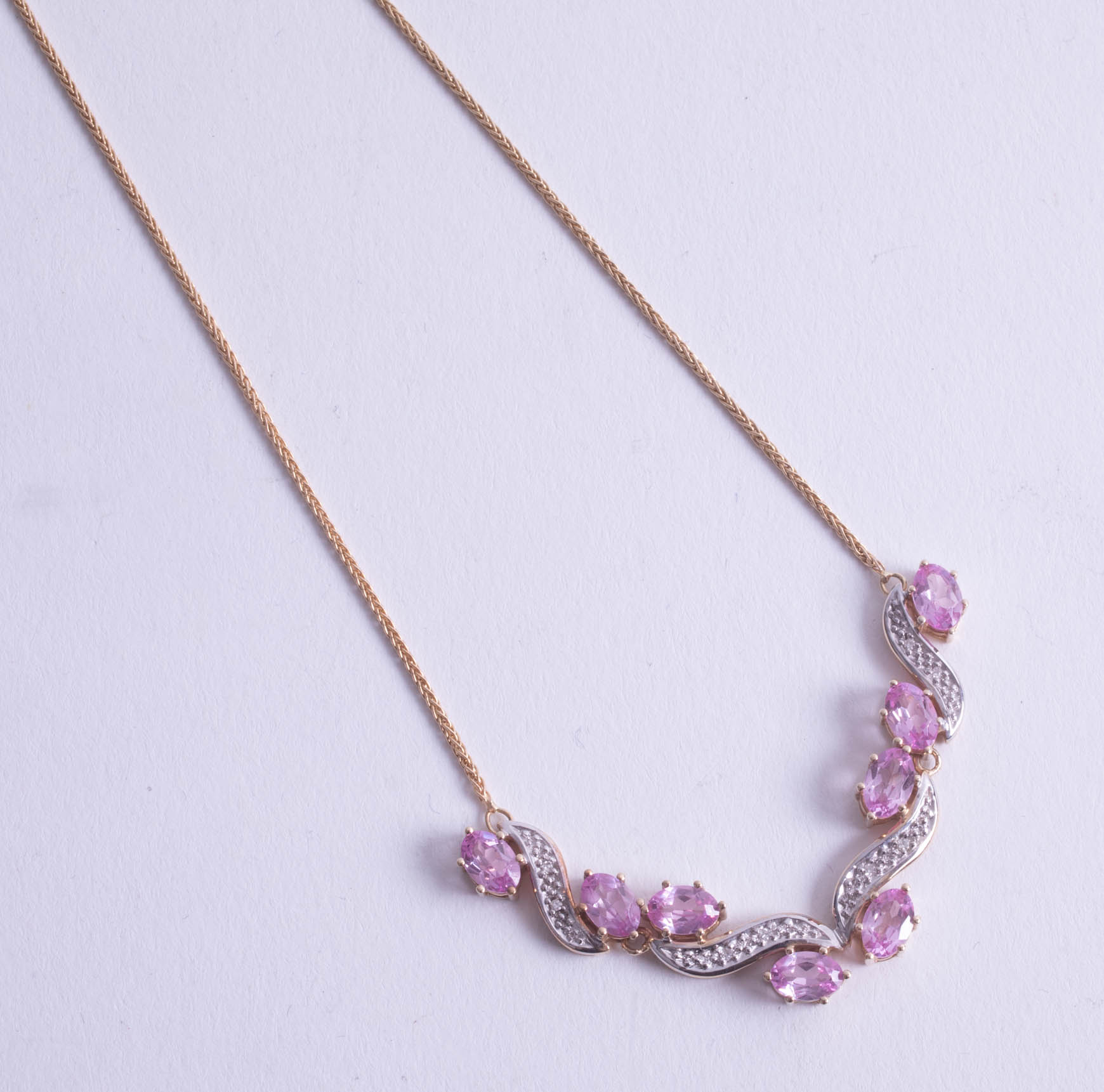 A stylish 14ct and pink sapphire and diamond set pendant.