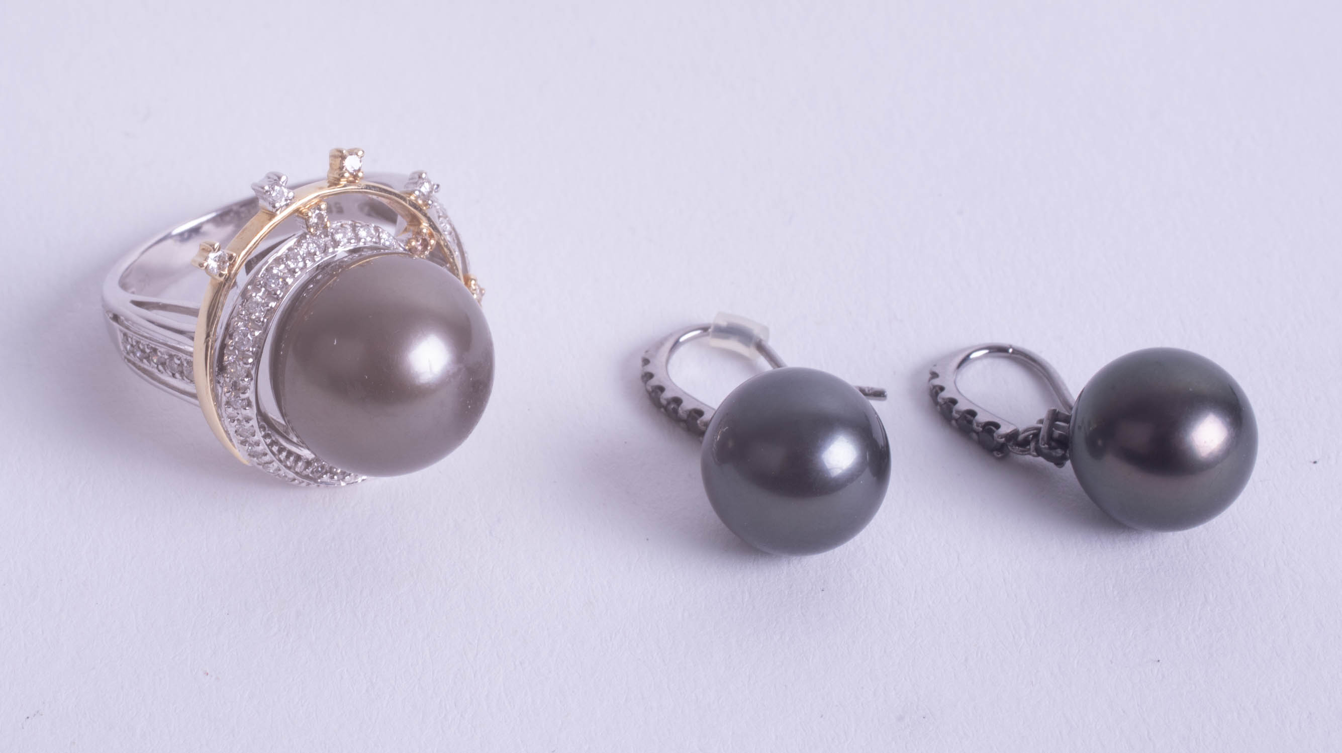 Black pearl and diamond ring, size P together with similar earrings.