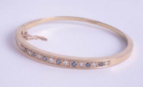 A 9ct sapphire and diamond set bangle, approx 14.20g.