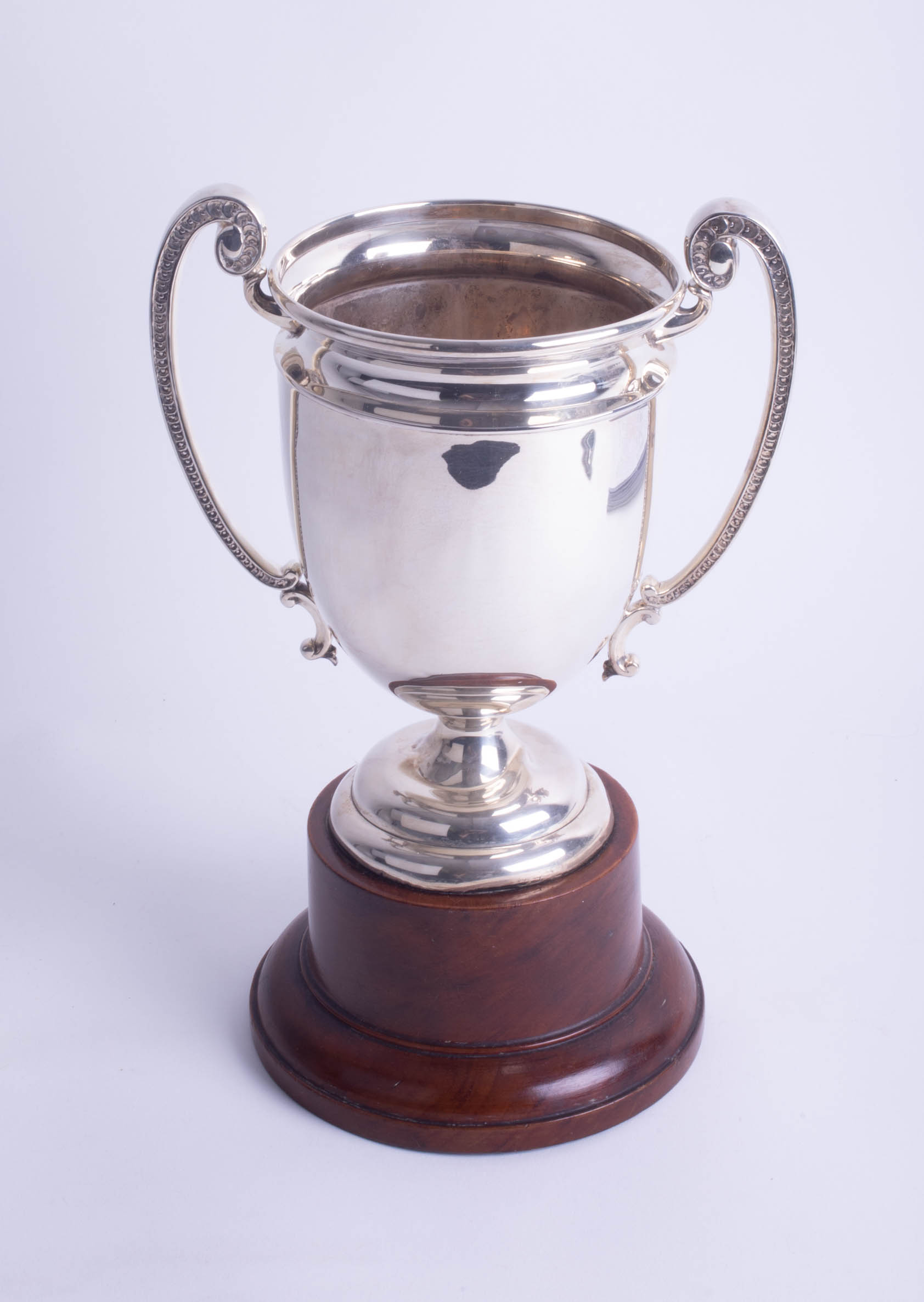 A Geo V silver twin handled trophy, height 20cm on wooden socle base, overall height 31cm.