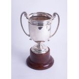 A Geo V silver twin handled trophy, height 20cm on wooden socle base, overall height 31cm.