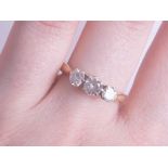 An 18ct three stone ring, the centre stone approximately 0.4 to 0.5 carats, size P, being sold to