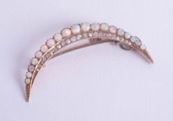 A antique opal and diamond set half crescent style brooch with safety chain, set with nineteen white
