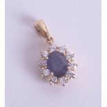 A sapphire and diamond cluster pendant set in 18ct yellow gold.