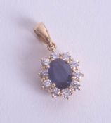 A sapphire and diamond cluster pendant set in 18ct yellow gold.