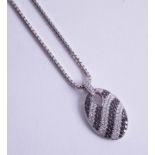 An 18ct black and white diamond set pendant and chain.