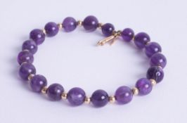 An amethyst and gold set bead bracelet, marked '750'.