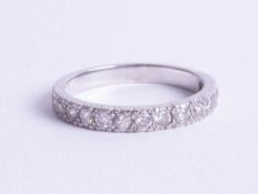 A platinum half band and diamond set eternity ring, set with fifteen diamonds, size N.