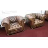 A pair of leather upholstered and button back chesterfield style club armchairs on small brass