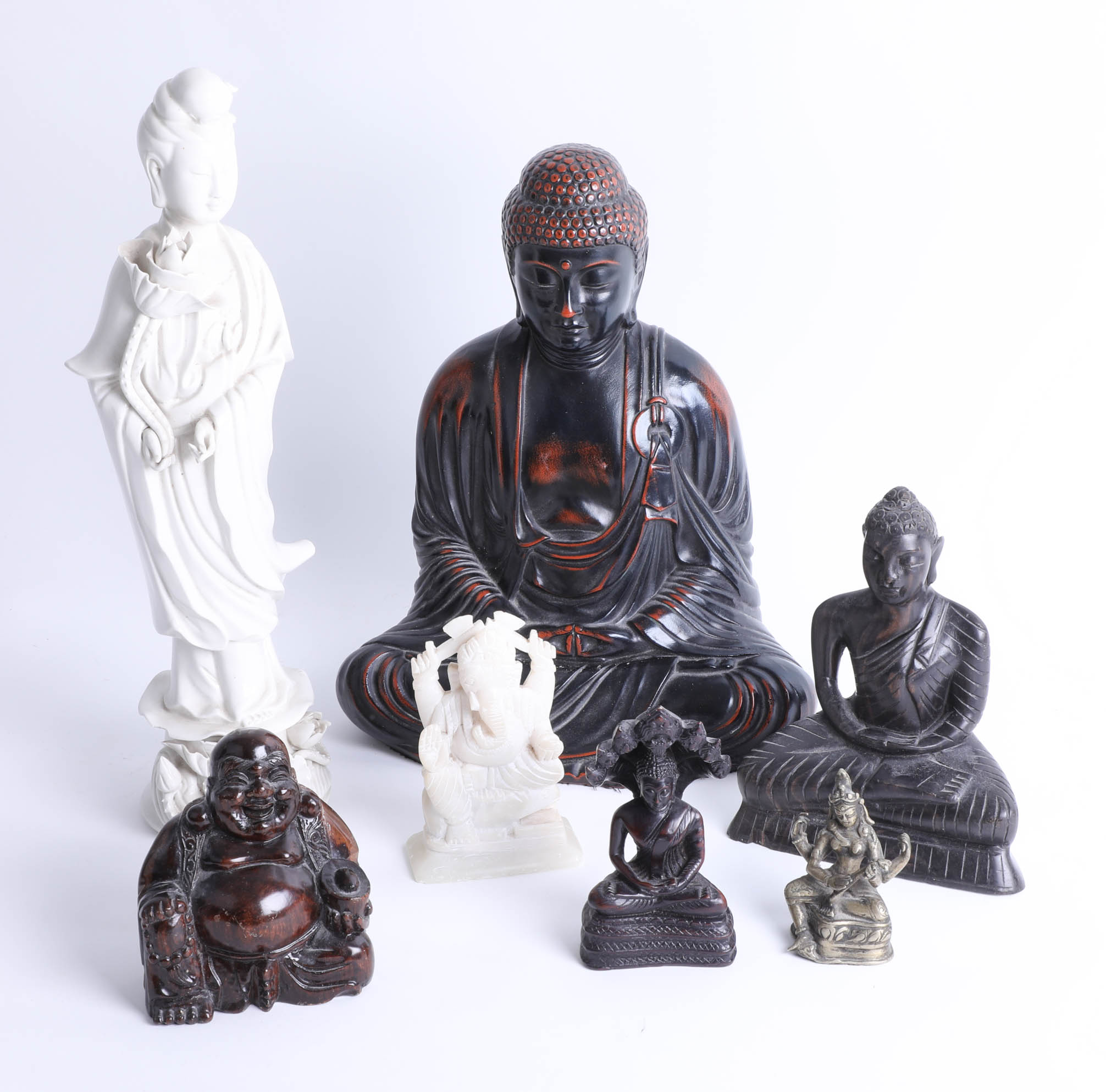 A carved wood Chinese Buddha height 22cm and a collection of six other oriental figures.