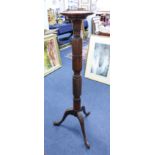 A carved mahogany torchere with tripod base.