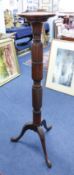 A carved mahogany torchere with tripod base.