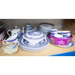 A collection of blue and white willow patterned dinnerware's together with an oriental teapot.