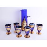 An ornate blue and gilt overlay Venetian glass set comprising wine jug and six glasses.