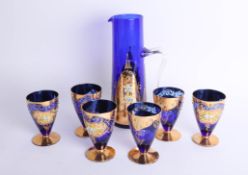 An ornate blue and gilt overlay Venetian glass set comprising wine jug and six glasses.