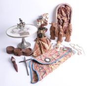 An interesting collection of eastern wood carvings, carved wooden plaques, doll, porcelain cake