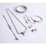 A contemporary silver jewellery set, bangle, earrings, pendant, necklace and ring, together with a