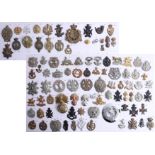 A collection of approx. 94 military cap badges displayed on two sheets, including an 1860 shako star