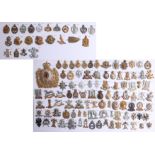 A collection of approx. 119 military cap badges displayed on two sheets, including a helmet plate