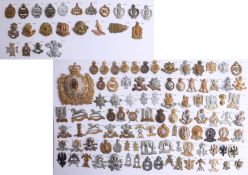 A collection of approx. 119 military cap badges displayed on two sheets, including a helmet plate