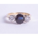 An 18ct sapphire and diamond set three stone ring, size P.