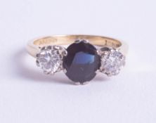 An 18ct sapphire and diamond set three stone ring, size P.