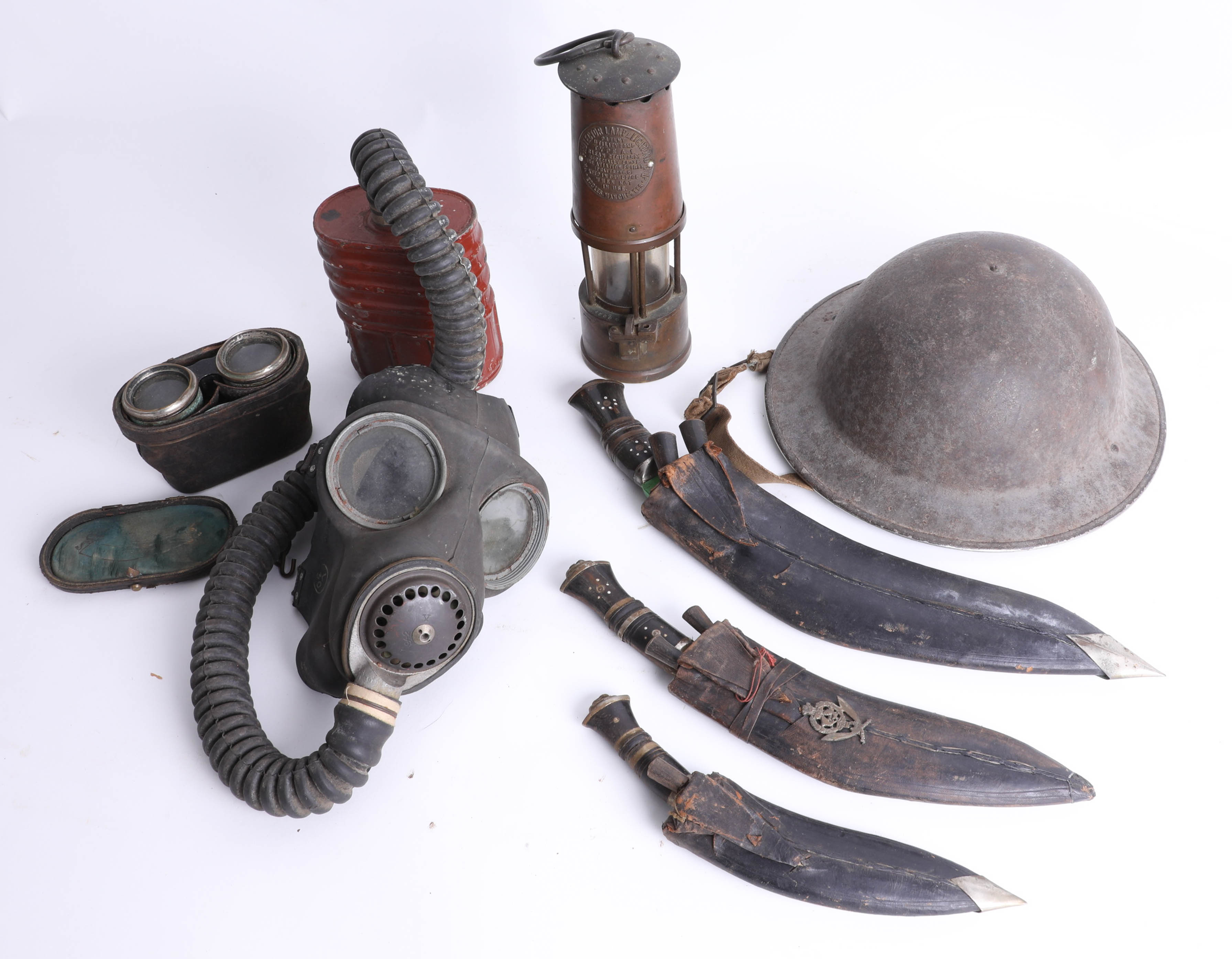 War time steel helmet, gas mask, Kukri knives, binoculars and vintage protector lamp.