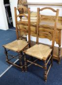 Pair of oak framed ladder back and rush seated side chairs.