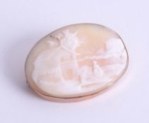 A rose gold oval cameo brooch depicting village scene, approx. 11.97g.