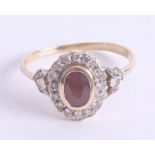 An 18ct yellow gold ruby and diamond halo ring, set with a oval facet cut centre ruby approx. 7.3