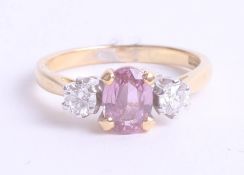 An 18ct pink sapphire and diamond three stone ring, 3.6g, size M.