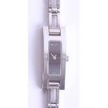 Gucci, a ladies wristwatch, with black dial and extra link on white metal bracelet with purchase