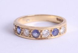 An 18ct sapphire and diamond half band ring set with seven stones, size N.