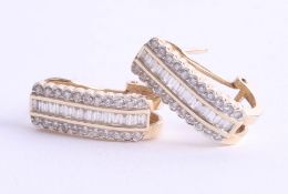 A pair of 14ct gold and diamond set earrings with a combination of round and baguette cut diamonds