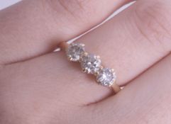An 18ct, three stone diamond ring, set in yellow gold, size K, the diamonds modern brilliant cut,
