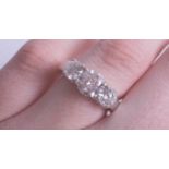 A fine platinum diamond three stone ring, with a platinum plain polished shank and head with four