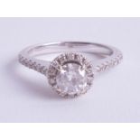 An 18ct white gold and diamond halo setting ring, approx. 1.00ct, estimate colour between I-J,