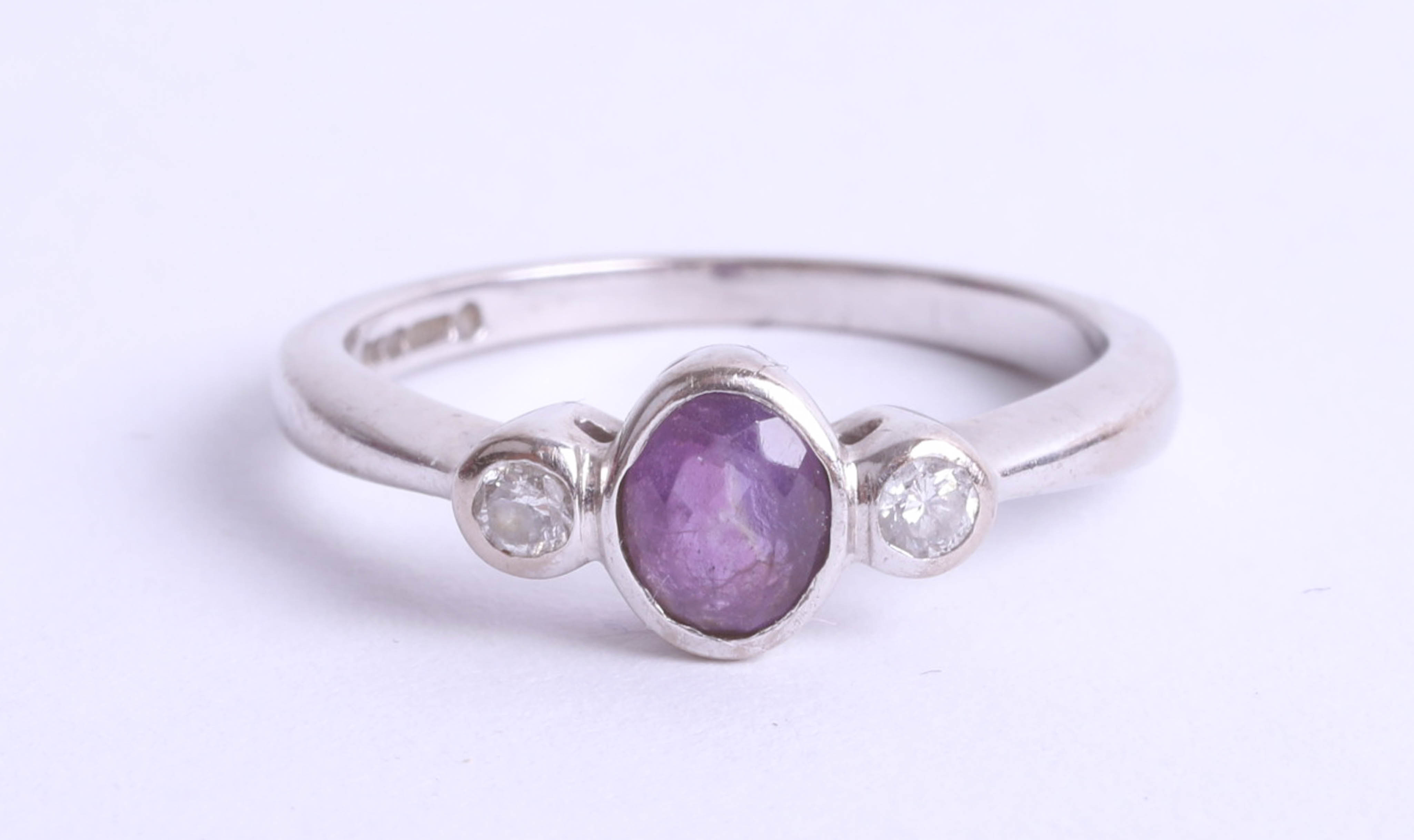 An 18ct white gold amethyst and diamond set three stone ring, size K.