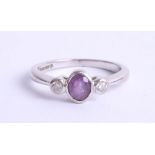 An 18ct white gold amethyst and diamond set three stone ring, size K.