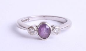 An 18ct white gold amethyst and diamond set three stone ring, size K.