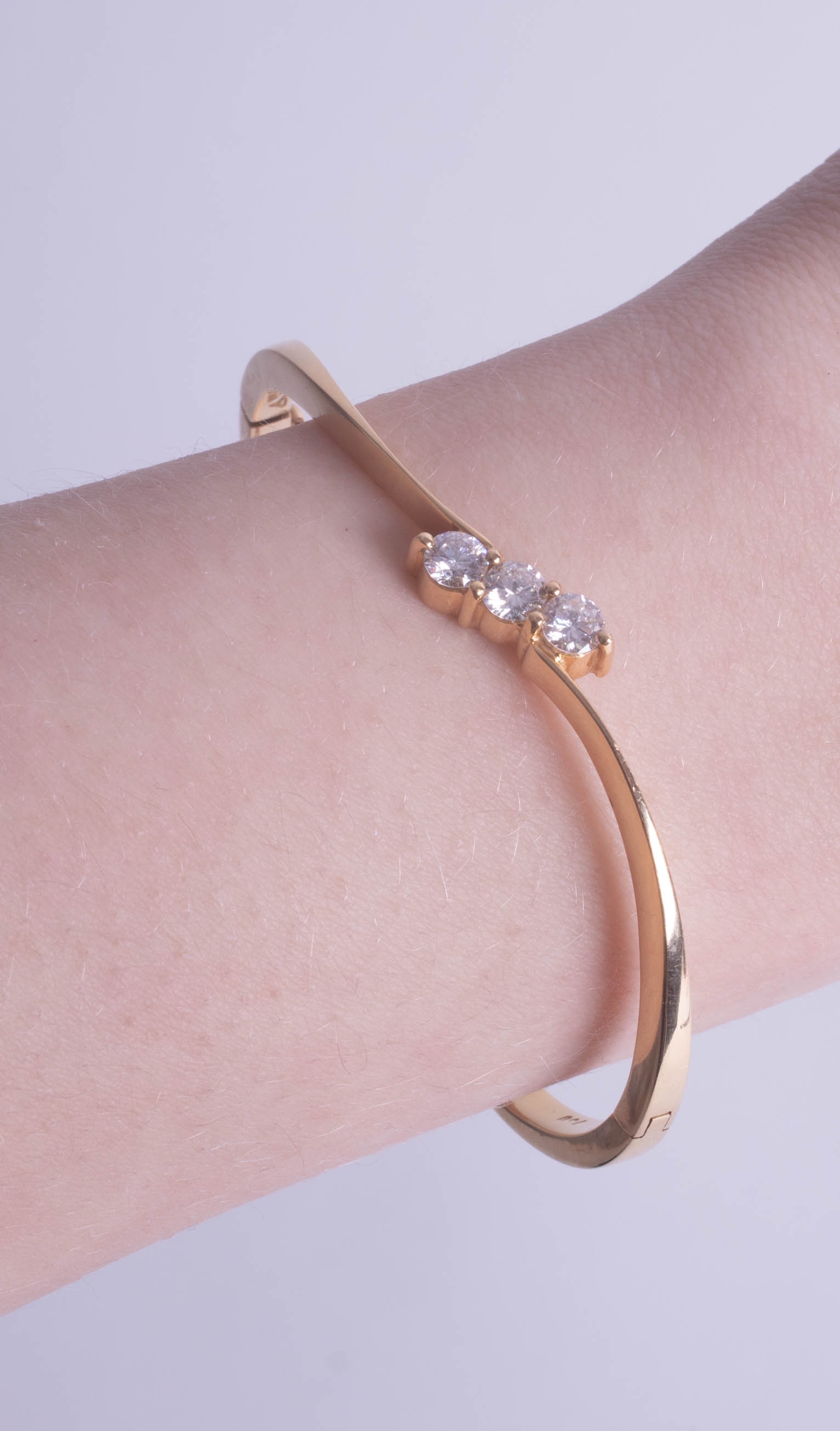 An 18ct three stone diamond cross over twist design bangle, approximately 63mm x 50mm, plain solid - Image 2 of 2
