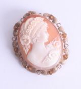 A large 9ct gold oval cameo brooch, depicting a period lady with floral hair decoration, approx