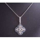 An 18ct white gold and diamond pendant set with seventeen round cut diamonds within a blue border